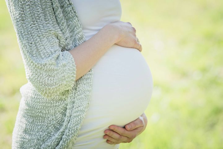 Femme enceinte les mains sur le ventre, ostéopathe grossesse Paris 19e